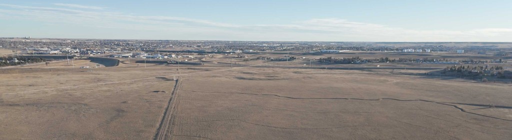 Aerial view of the Hitching Post site in Cheyenne, with open prairie in the foreground and the city on the horizon.